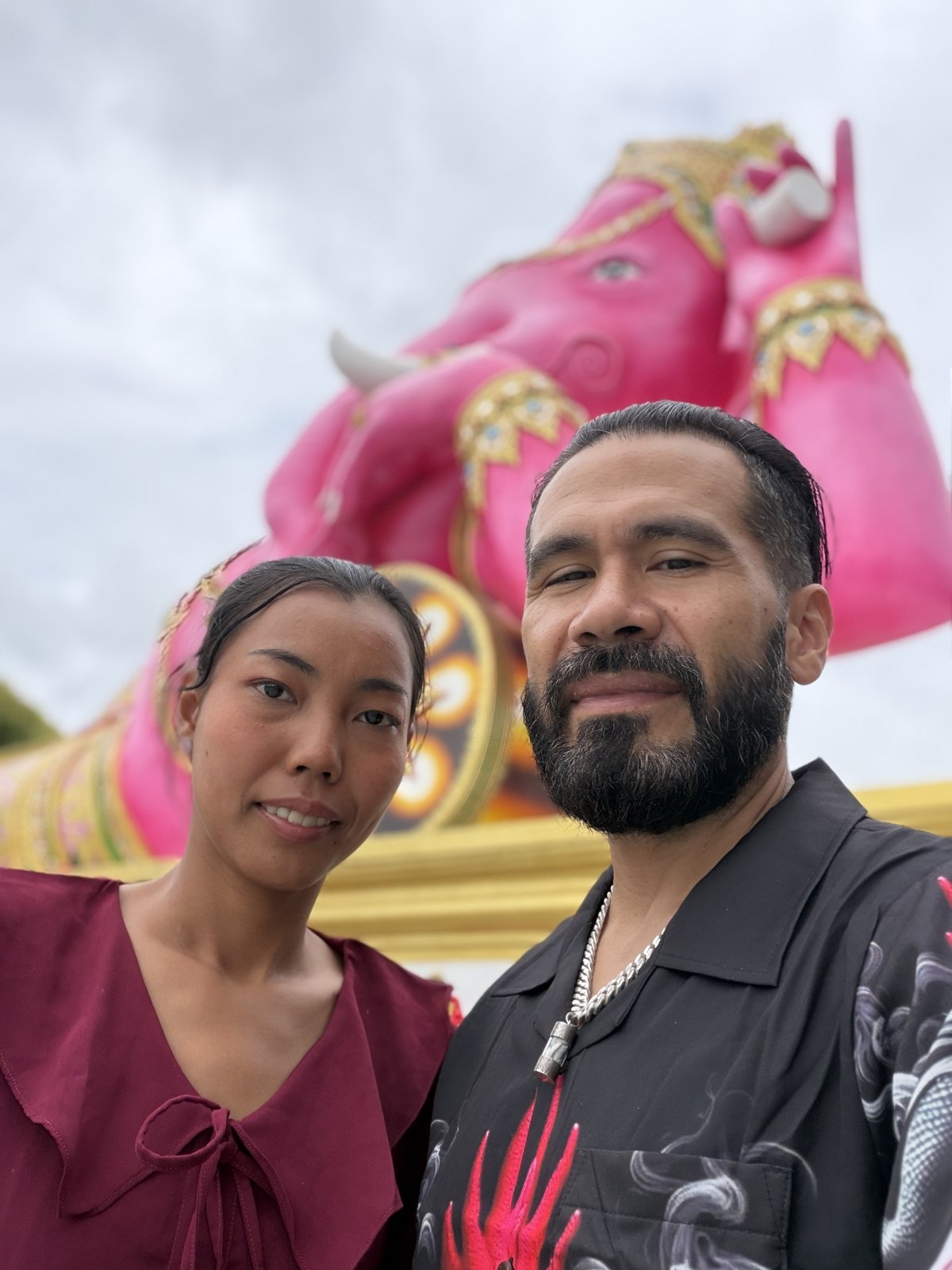 Josh and Siriwan in front of the reclining pink Ganesha at Wat Saman Rattanaram.